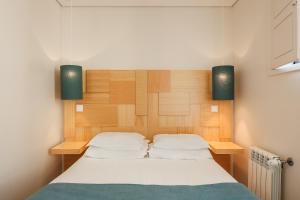 波尔图博阿维斯塔宾馆的一间卧室配有一张带木制床头板的床