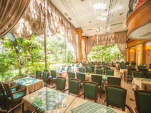 埔里镇宝大饭店的用餐室配有桌子和绿色椅子