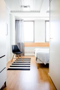 罗瓦涅米咖啡之家旅舍的卧室配有一张床和一把椅子,靠窗