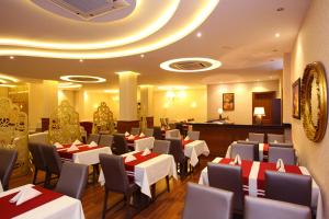 埃利特温泉Ugur Termal Residence的一间设有白色桌椅的餐厅和一间酒吧