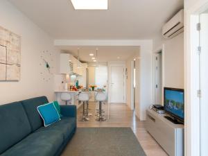 圣阿古斯丁Apartment Las Burras Aquarius09的一间带蓝色沙发的客厅和一间厨房