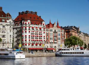 斯德哥尔摩斯德哥尔摩外交官酒店的两艘船在水中,在建筑物前