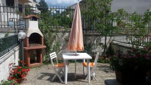 桑格罗堡La Montanara Apartment的一张桌子和椅子,配有雨伞和烤箱