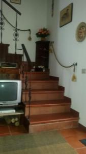 桑格罗堡La Montanara Apartment的一间带电视和楼梯间的房间