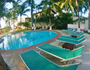 新巴利亚塔Splash Inn Nuevo Vallarta & Parque Acuatico的一个带躺椅的游泳池,棕榈树