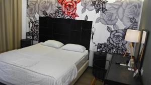 帕特雷阿多尼斯城市酒店的一间卧室设有一张床和鲜花墙