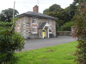 CloverhillCloverhill Gate Lodge的一座古老的石头房子,设有黄色的门