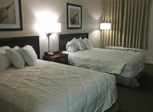 克兰顿Inn of Clanton的酒店客房设有两张床和两盏灯。