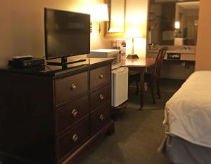 克兰顿Inn of Clanton的酒店客房带一个梳妆台,上面有电视