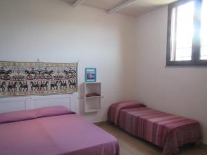 特乌拉达B&B Su Tostainu的一间卧室设有两张床和窗户。