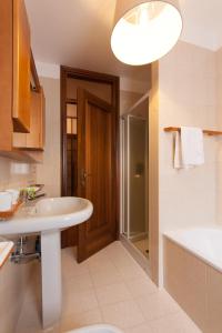乌迪内Toti Apartment的一间带水槽、淋浴和卫生间的浴室