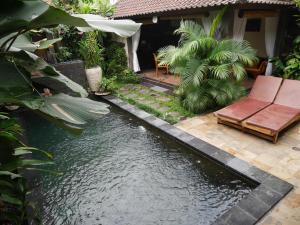 乌布Pondok Penestanan Villa Ubud的后院设有带长沙发和椅子的池塘