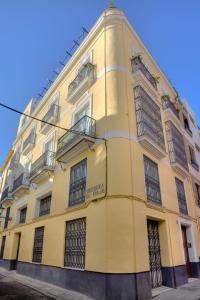 塞维利亚Reservaloen Casa del Museo的街道上一座黄色建筑,有铁窗