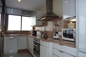 多列毛利诺斯La Nogalera 7的厨房配有白色橱柜和微波炉