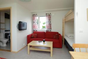 哈尔姆斯塔德古尔布拉南花园假日公园的客厅配有红色的沙发和床。