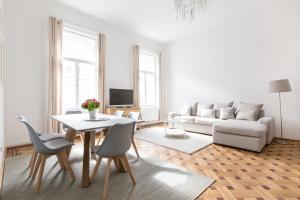 维也纳市中心极佳公寓的客厅配有桌子和沙发