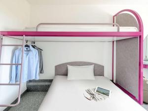 舍讷费尔德宜必思柏林舍讷费尔德机场快捷酒店的双层床配有粉红色的双层床架