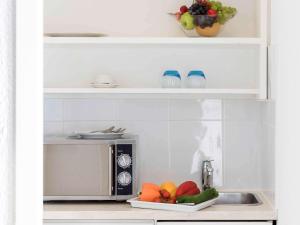 日内瓦日内瓦中心一室公寓的厨房配有微波炉和一盘水果