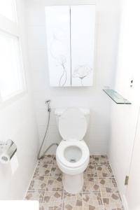 首尔克里宾馆的白色的浴室设有卫生间,墙上挂有一些图画
