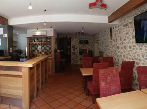 Bélesta帕莱斯卡特里酒店的一间带桌子和红色椅子的餐厅和一间酒吧