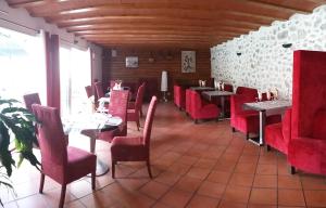 Bélesta帕莱斯卡特里酒店的一间餐厅,房间内设有红色的椅子和桌子