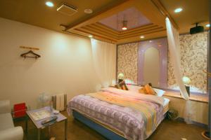 Shijonawateオーラリゾート四條畷的一间卧室配有一张带窗户和桌子的床