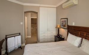 德班702 Oyster Rock - by Stay in Umhlanga的一间卧室配有一张床、梳妆台和衣柜。
