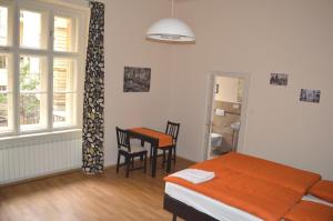 布拉格瓦伦蒂娜旅舍的卧室配有一张床和一张桌子及椅子