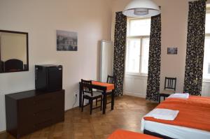 布拉格瓦伦蒂娜旅舍的一间卧室配有一张床、一台电视和一张桌子