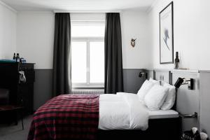 英格堡英格堡滑雪酒店的一间卧室配有一张带白色床单的床和一扇窗户。