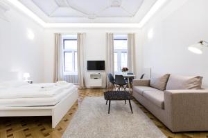 维也纳市中心极佳公寓的白色的客厅配有床和沙发