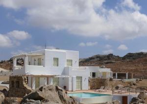 VívlosVillas Naxos Grande Vista的沙漠中带游泳池的白色房子