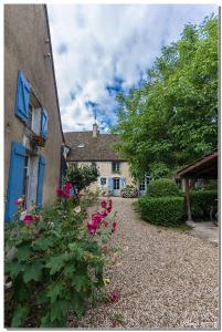 Corcelles-les-ArtsLa Cuverie du Château的一座房子,旁边是粉红色的花