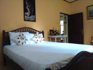 尼甘布Illumination Stay的卧室配有一张带白色床单和枕头的大床。