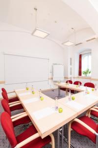 布拉格埃克城市公园酒店的一间会议室,配有长桌子和红色椅子