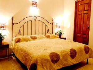 瓦哈卡市Hotel Dainzu的一间卧室配有一张带黄色毯子的大床
