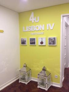 里斯本4U Lisbon IV Guesthouse Airport的一间设有黄色墙壁的房间,带有课程的iv标志