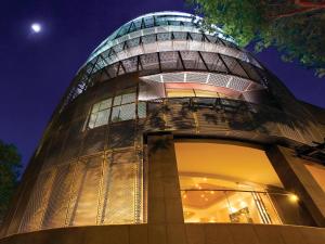新加坡D'Hotel Singapore managed by The Ascott Limited的一座晚上有玻璃圆顶的建筑