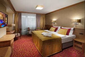什平德莱鲁夫姆林和谐俱乐部酒店的酒店客房配有一张带黄色和红色枕头的大床。