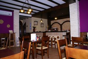 阿尔马登德拉普拉塔艾尔罗梅拉尔酒店的一间带桌椅的用餐室和一间酒吧
