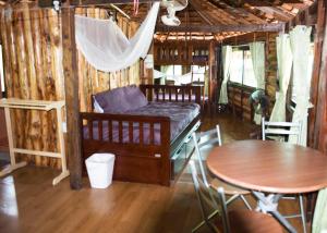 皮皮岛向日葵船屋的配有一张床和一张桌子及椅子的房间