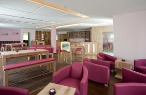 沃尔姆斯安什洛斯帕克别墅酒店的一间设有紫色椅子和桌子的等候室