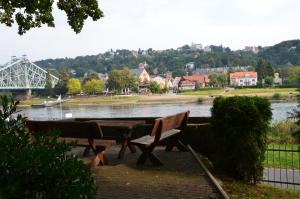 德累斯顿Ferienwohnung an der Elbe的河边野餐桌和长凳