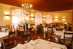仕格莱伊瓜莱纳酒店的餐厅配有白色的桌椅和吊灯
