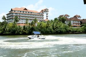 奎隆The Leela Ashtamudi, A Raviz Hotel的船在水中,停在酒店前