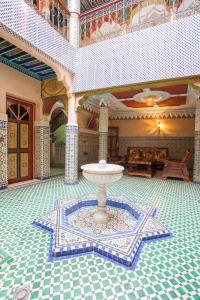 马拉喀什里亚德哈姆扎住宿加早餐旅馆的建筑中间带喷泉的房间