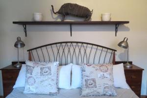 比勒陀利亚哈特菲尔德乡村旅馆的一间卧室配有带枕头和架子的床