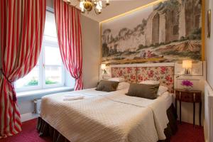 克拉科夫波尔斯基比亚莱姆奥尔莱姆酒店的卧室内的两张床,配有红色窗帘