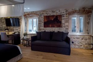斯普利特穆鲁姆遗产酒店的带沙发和石墙的客厅