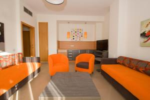 阿尔考斯布里阿尔克瑟布雷套房酒店的客厅配有橙色椅子和沙发